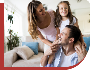 A couple with a child smiling and having fun together in their home